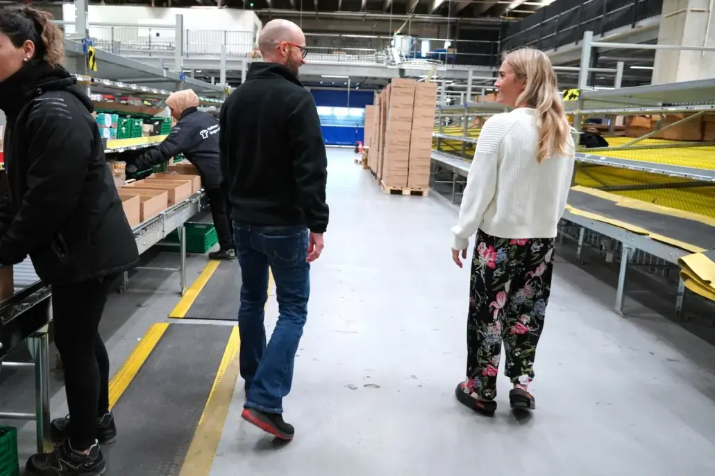 Meal-kit boxes on the HS line at Godt Levert with operators walking along it
