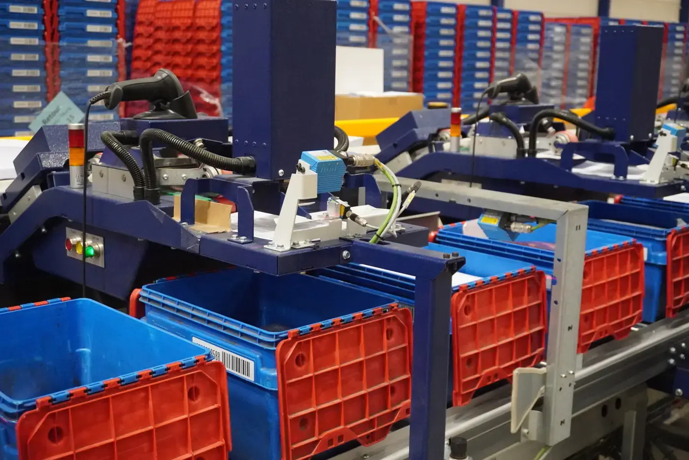 Stacks of grey and blue totes on an HS conveyor at ID Logistics