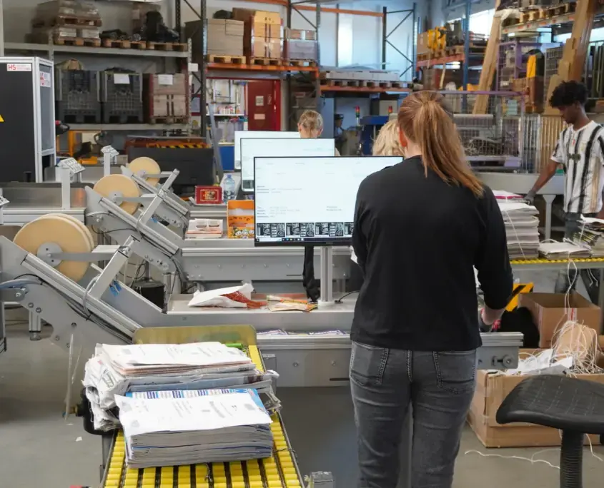 An operator working at an HS returns line with monitor and conveyors