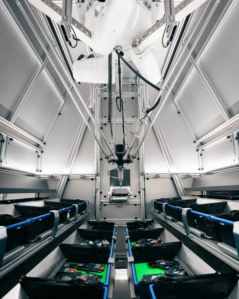 The HS AI pick robot inside its cell, with camera and vacuum gripper above the picking area